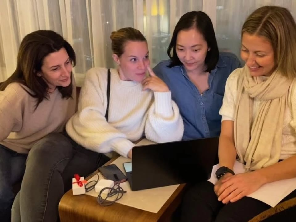 Nicole and three lab colleagues looking at a laptop together