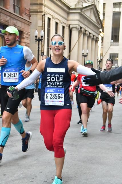 Nicole running the Chicago Marathon, high-fiving the crowd