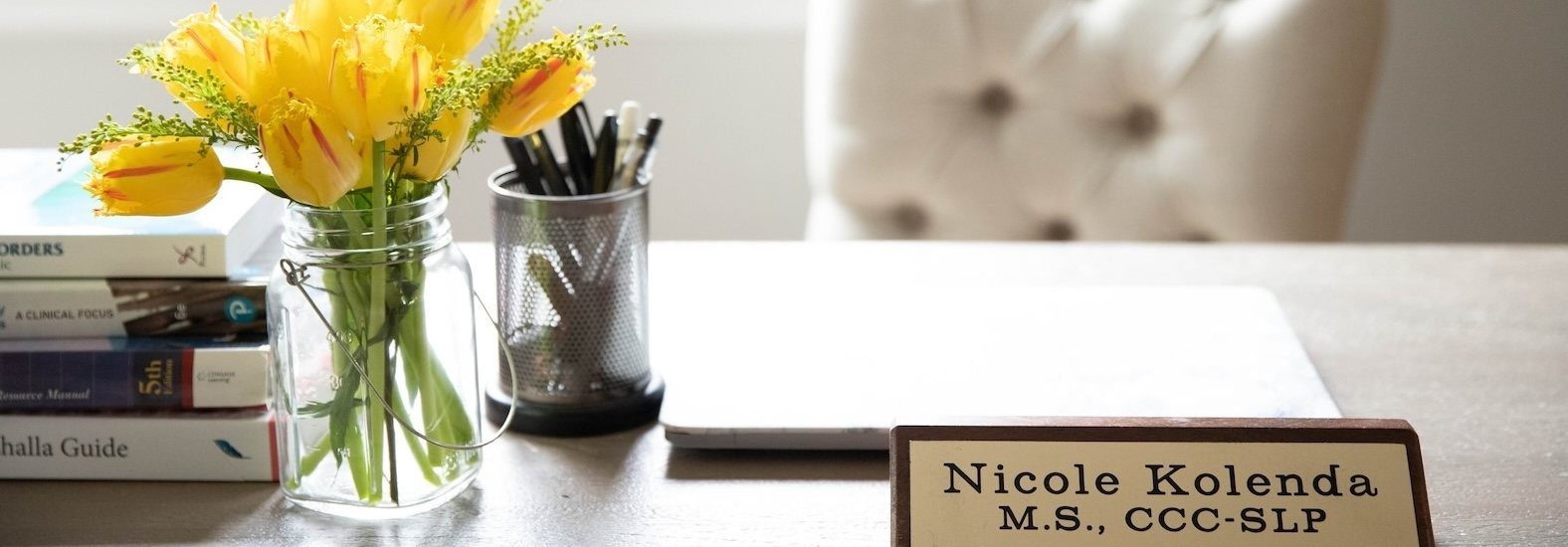 Nicole's desk with yellow tulips and her nameplate