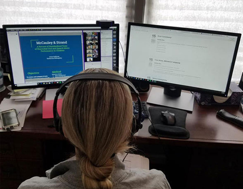 Woman working on two monitors