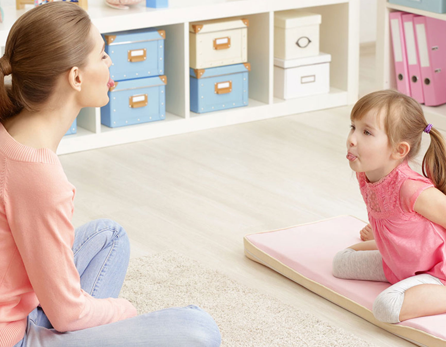 Therapist and girl sticking toungs out